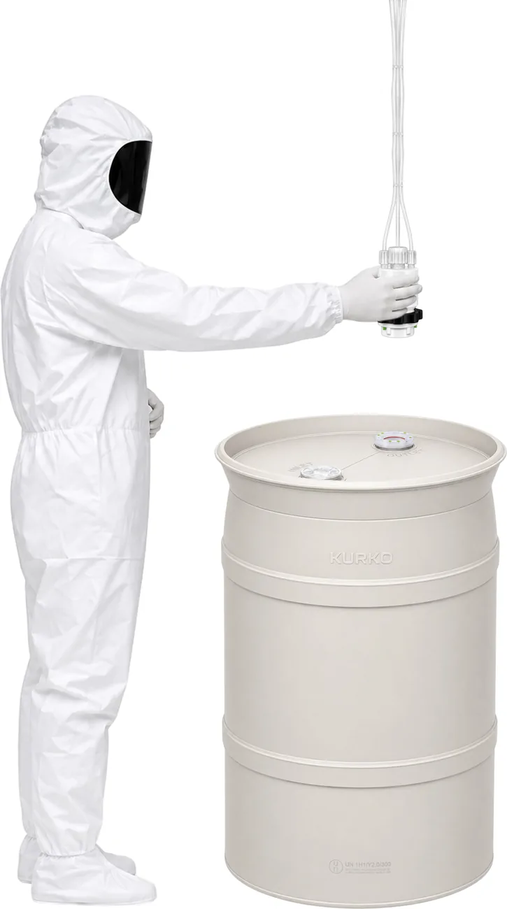 Gowned operator lowering a KoLink Dispense Head toward the keyed outlet of an HP55 drum